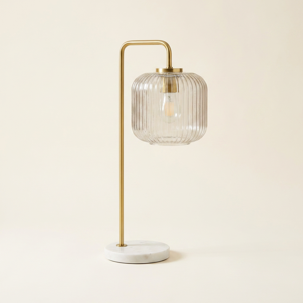 Haven Clear Glass Table Lamp With Gold Brush Metal And Marble Base on a warm cream background