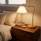 Ornate Brass Ring Base Curved Table Lamp With Triangle White Drum Shad styled in a warm modern interior